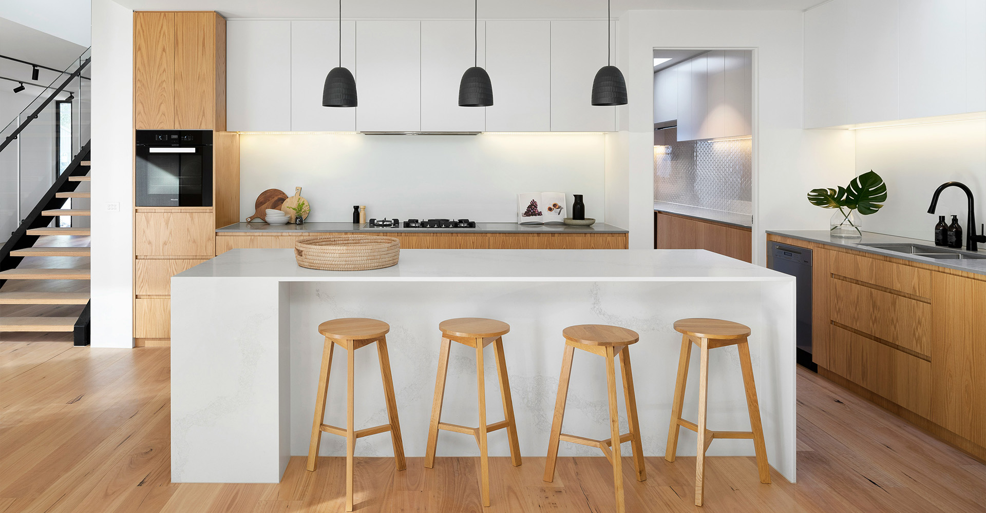 Niche cuisine sur mesure La Belle Cuisine, façades laquées noir mat et plan bois clair rétroéclairé